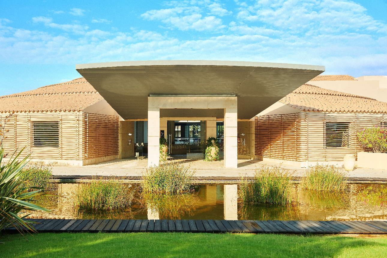 The exterior of a large building with a pond in front of it