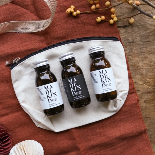 natural products in three bottles on wash bag