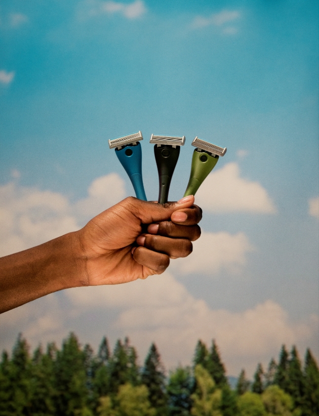 A person holding three razors