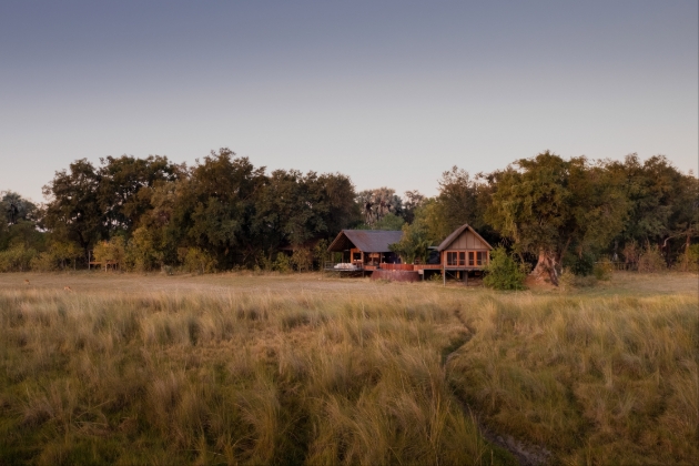 A red and wood building in a field