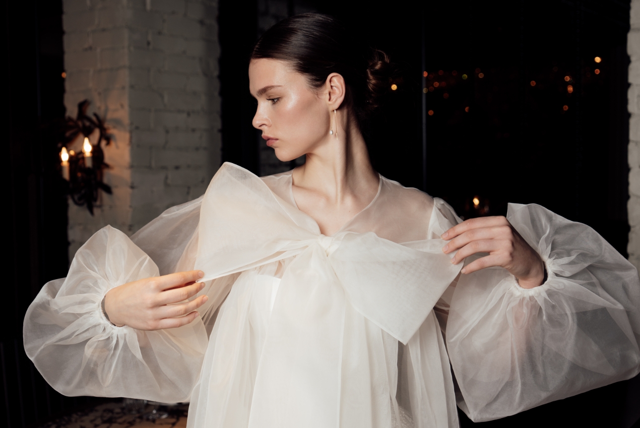 model in sheer dress with big bow on front