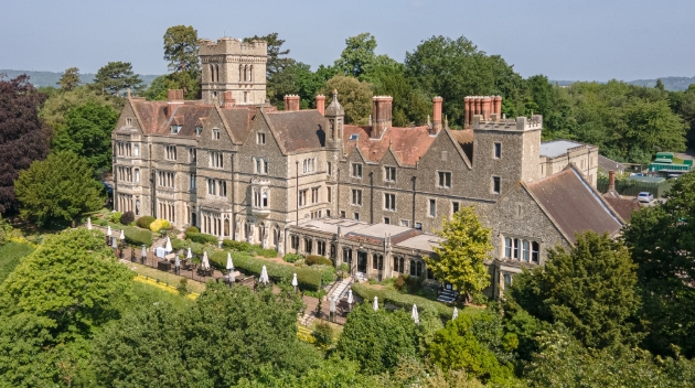 Nutfield Priory historic building surrounded by trees with view