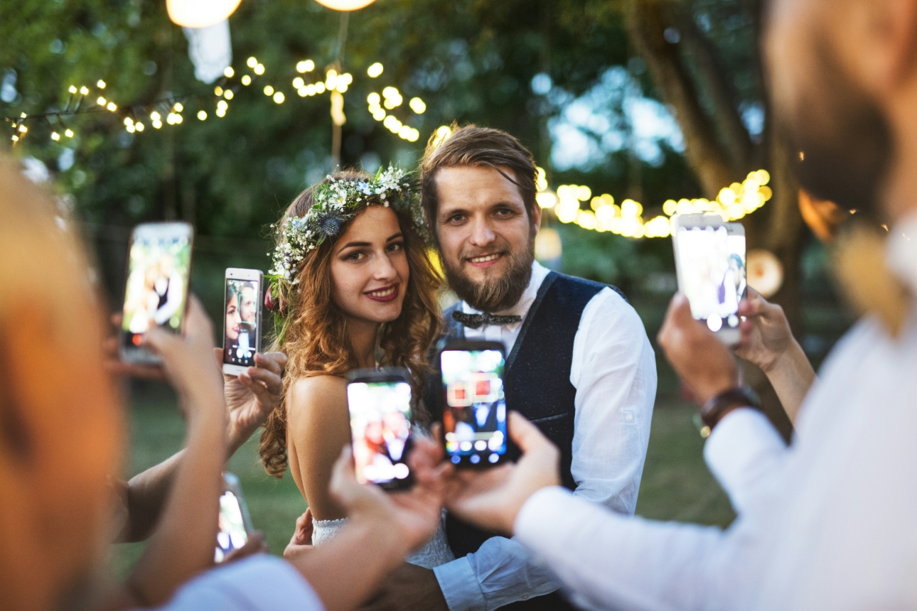 couple surrounded by smartphone cameras 